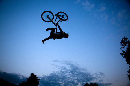 Silhouette of a man doing a jump with a bmx bike の写真素材