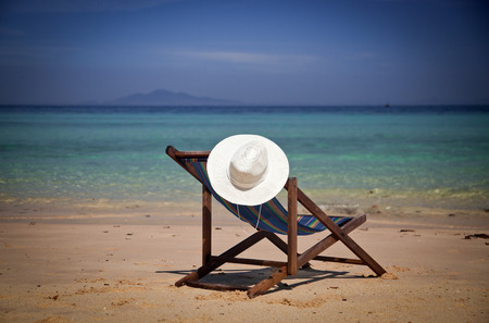 Exotic beach holiday background with white hate on beach chairの写真素材