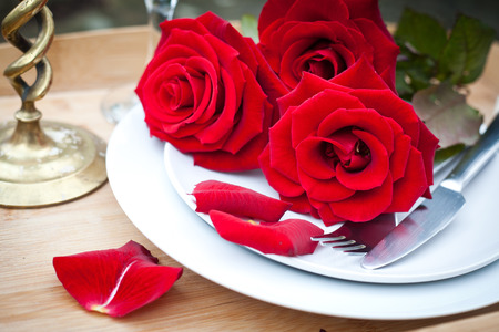 Table setting with red roses on plate - celebrating Valentine'sの写真素材