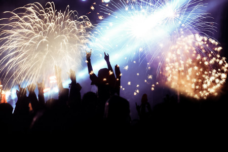 cheering crowd watching fireworks at New Year - holiday celebration background
