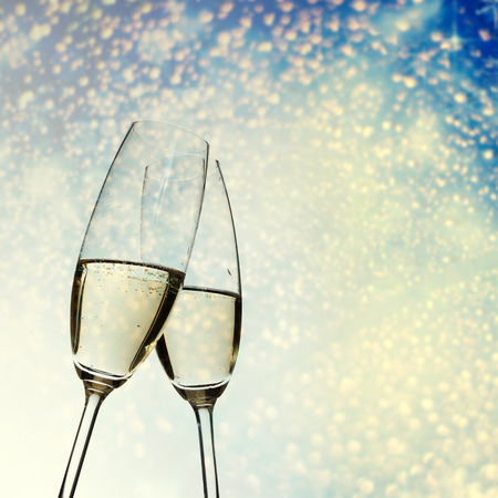 toasting with champagne glasses against holiday lights - New Year backgroundの写真素材