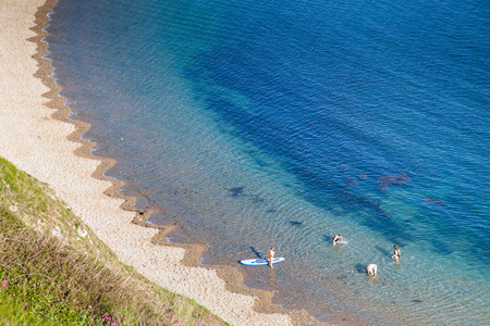 people enjoying a hot summer day on a beautiful hidden beach on the Jurassic Coast of Dorset, UK - Britiish summer holiday destinationの写真素材