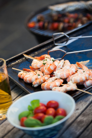 barbecue in the garden - summer- prawns and vegetables on skewersの写真素材
