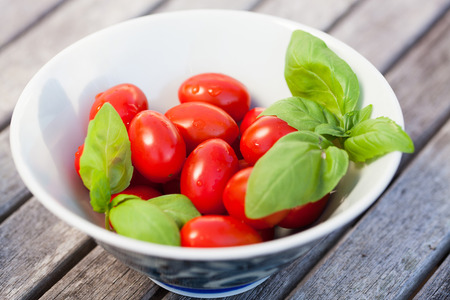 tomatoes with basil on wooden tableの写真素材