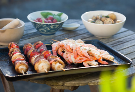 barbecue in the garden - summer- prawns and vegetables on skewersの写真素材