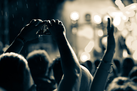 crowd with raised hands at concert - summer music festivalの写真素材