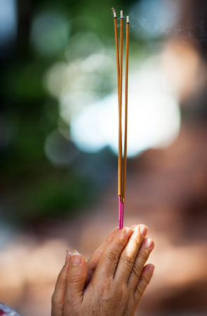 incense sticks in hands of praying perseonの写真素材