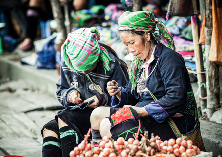 SA PA, VIETNAM - AUGUST 2017: Portrait of black hmong ethnic minority woman selling goods and sewing at the market in Sa Pa town, the high mountains, Lao Cai province, Vietnamのeditorial素材
