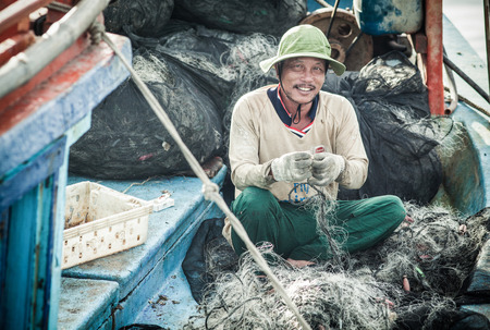 NAM DU, VIETNAM - JULY 27, 2017: Local fishermen working on their boats in Hon Tre pier, early morning, Nam Du Islands, Kien Giang, Vietnamのeditorial素材