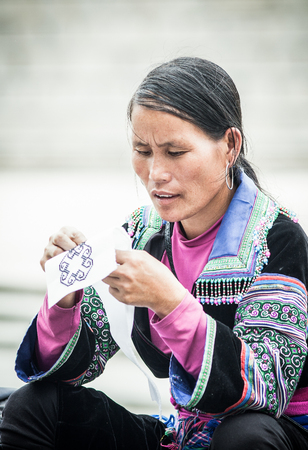 SA PA, VIETNAM - AUGUST 2017: Portrait of unidentified hmong woman sewing in Sa Pa town, the high mountains, Lao Cai province, Vietnam.のeditorial素材