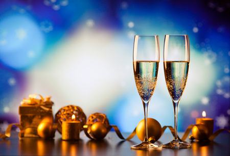 two champagne glasses against holiday lights and fireworks - new year celebrationの写真素材