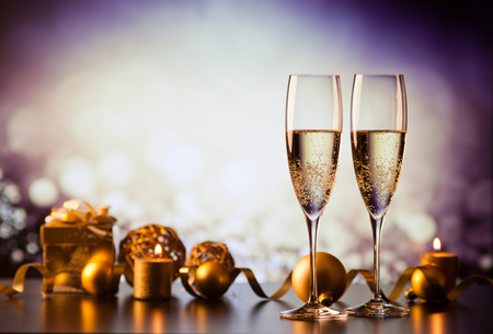 two champagne glasses against holiday lights and fireworks - new year celebrationの写真素材
