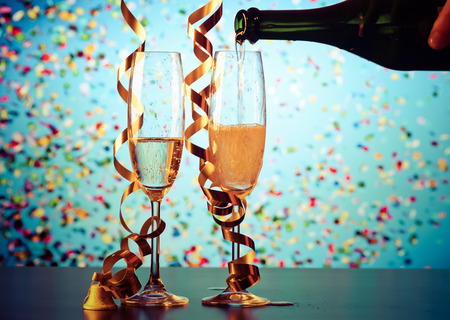 two champagne glasses with ribbons and falling confetti - New Year celebrationsの写真素材