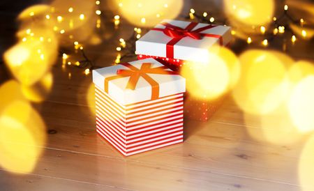 red gift boxes and christmas lights on wooden floorの写真素材