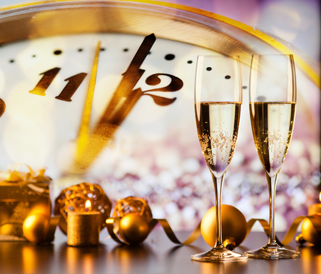 two champagne glasses against holiday lights and fireworks - new year celebrationの写真素材