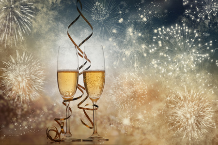 two champagne glasses with ribbons against holiday lights and fireworks - New Year celebrationsの写真素材