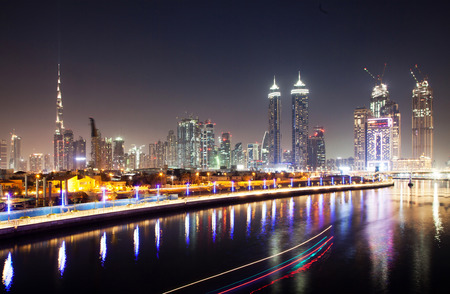 DUBAI, UAE - FEBRUARY 2018: Colorful sunset over Dubai Downtown skyscrapers and the newly built Tolerance bridge as viewed from the Dubai water canal.のeditorial素材