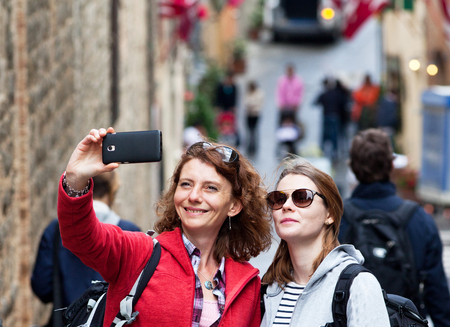 female tourists taking a selfie in medieval town のeditorial素材