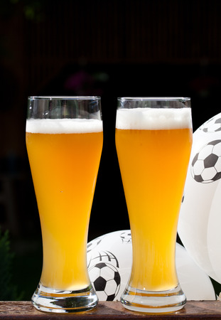 two glasses of beer and balloon with footballs - watching soccerの写真素材