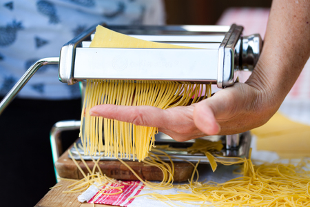woman's hands cutting home made pastaの写真素材