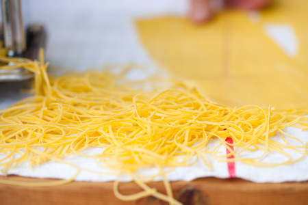 woman's hands cutting home made pastaの写真素材