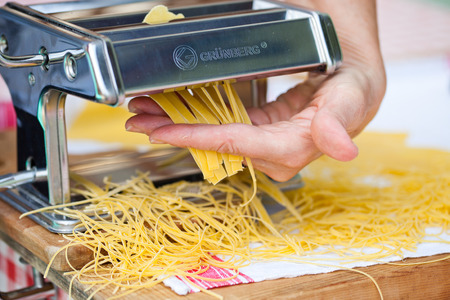 woman's hands cutting home made pastaの写真素材