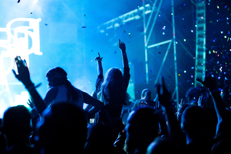 cheering crowd with raised hands at concert - music festivalの写真素材