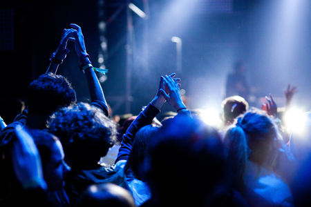 cheering crowd with raised hands at concert - music festivalの写真素材