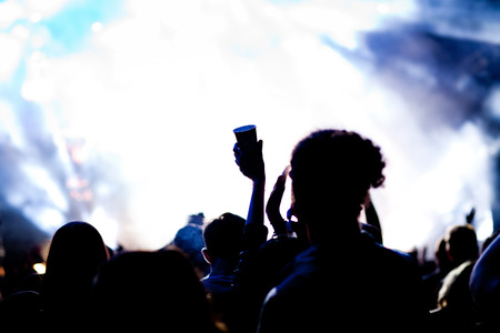cheering crowd with raised hands at concert - music festivalの写真素材