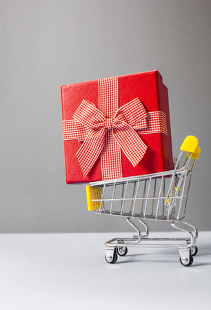 huge red gift box in shopping cart - online shoppingの写真素材