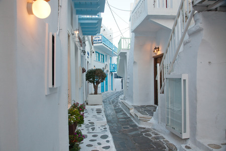 traditional narrow street in Mykonos with blue doors and white wallsの写真素材