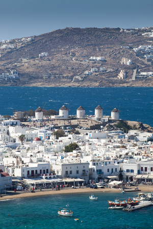 panoramic view of the Mykonos town harbor with famous windmills from the above hills on a sunny summer day, Mykonos, Cyclades, Greeceの写真素材