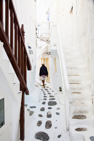 traditional narrow street in Mykonos with blue doors and white wallsの写真素材