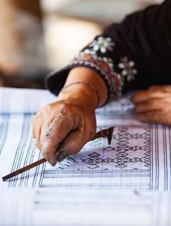 hmong woman drawing the patterns for beautiful handmade fabrics of hill tribe people of Thailandの写真素材