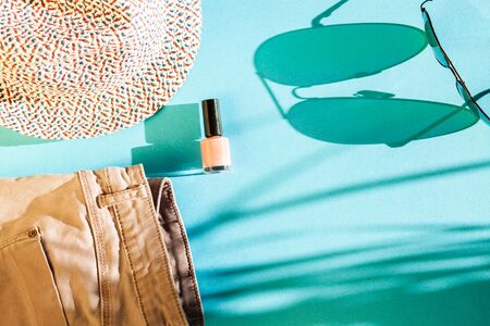 woman clothes and accessories top view. modern and casual outfit on bright sunny blue background. fashion  shopping and makeup concept. Flat lay for beauty bloggersの写真素材