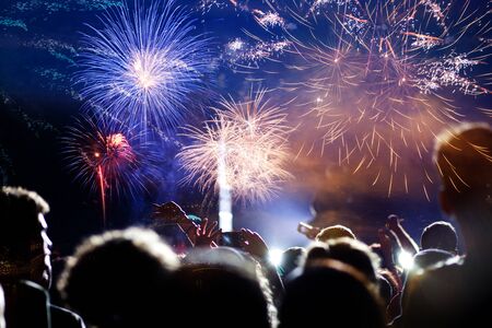 crowd celebrating New Year with fireworksの写真素材