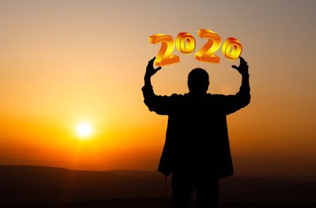 man silhouette holding 2020 in sunsetの写真素材