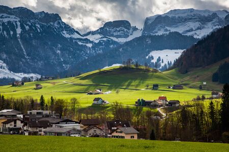 small mountain village and snowy Alps Switzerlandの写真素材
