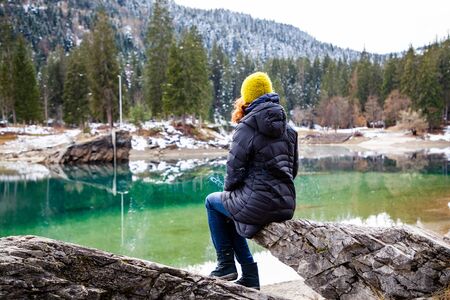woman watchin amazing turquoise water of Caumasee in winter Switzerland slow travel