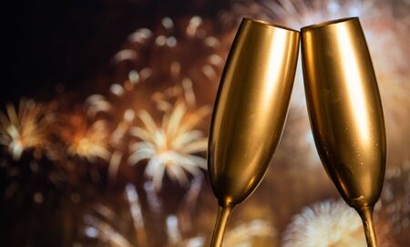 golden champagne glasses and fireworks at new yearの写真素材