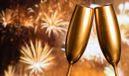 golden champagne glasses and fireworks at new yearの写真素材
