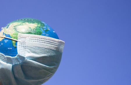 coronavirus world alert - surgical mask on globeの写真素材