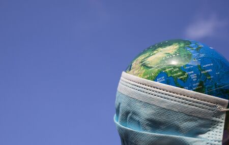 coronavirus world alert - surgical mask on globeの写真素材