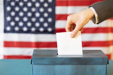 usa elections  the hand of woman putting her vote in the ballot box