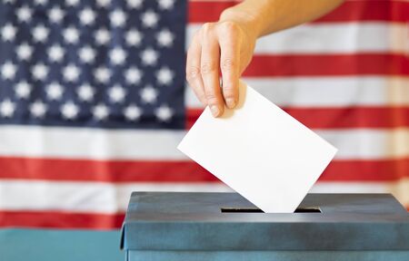 usa elections  the hand of woman putting her vote in the ballot box