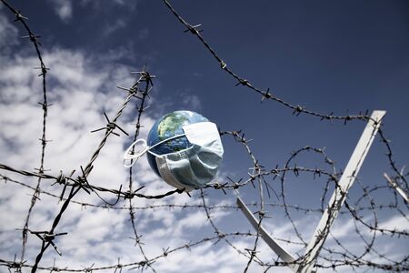 coronavirus global fight concept - COVID-19 - face mask on globeの写真素材