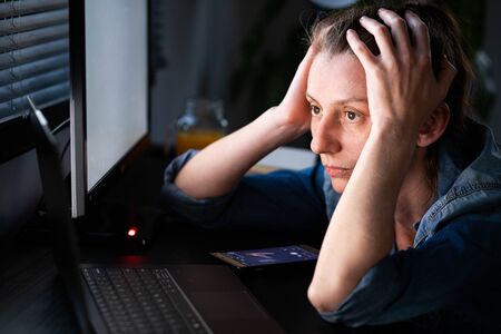 depressed woman working from home holding her head