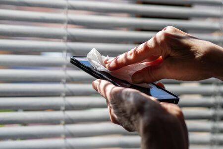 woman hands cleaning smartphone  sanitizing  coronavirus prevention