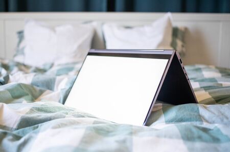 laptop or tablet in bed white empty screen for copy space
