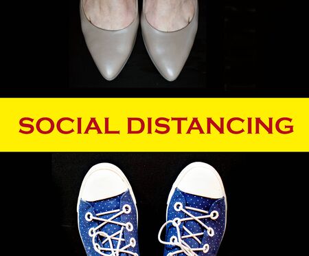 social distancing concept foot wearing sneakers and woman wearing high heelsの写真素材